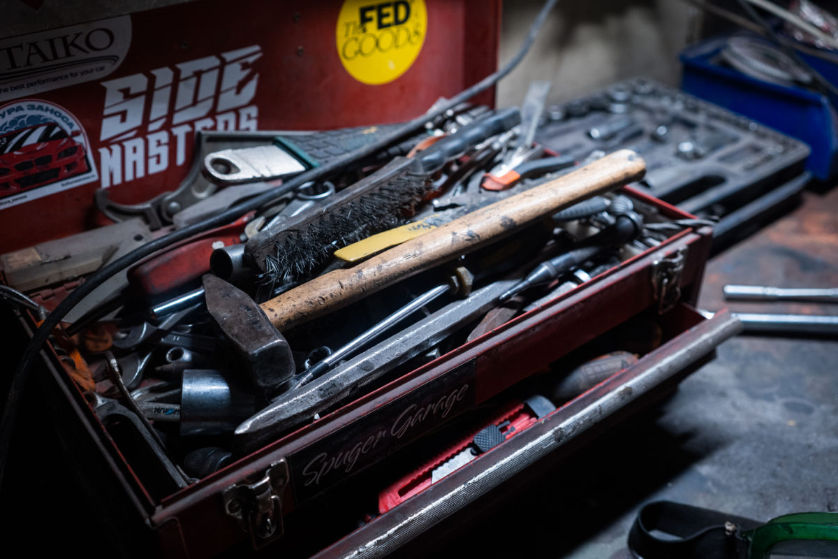 A well-used red toolbox overflowing with hammers, spanners and other tools